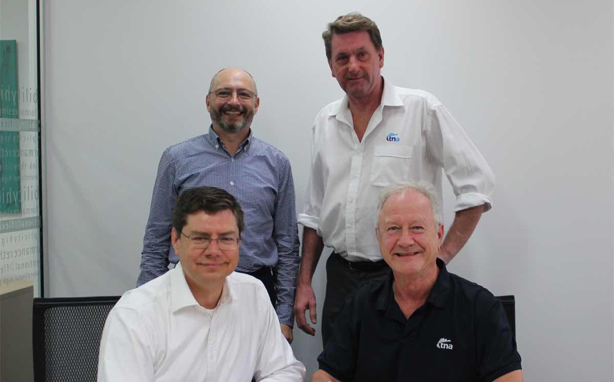 The deal was welcomed by executives of both companies, including CEOs Mark Mueller (front, left) and Alf Taylor (front, right).